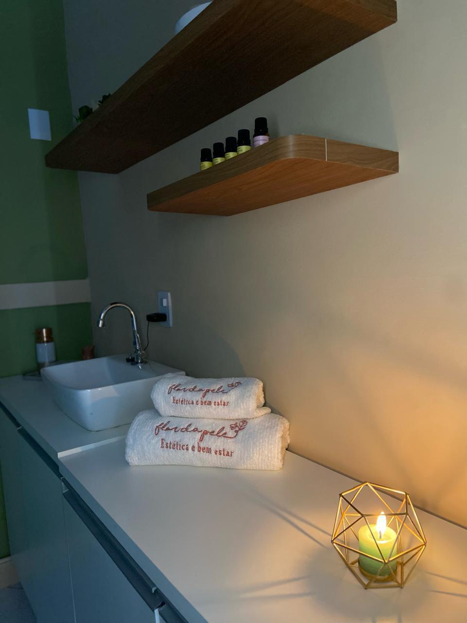 Bancada com toalhas bordadas e velas aromáticas